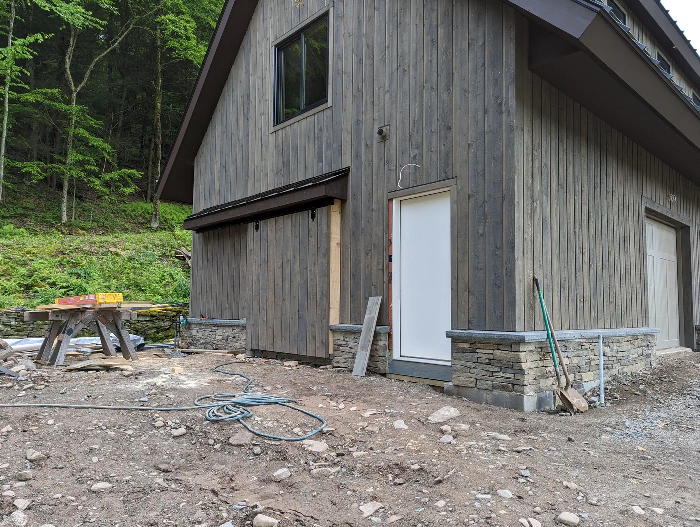 Vertical board siding over a stone base