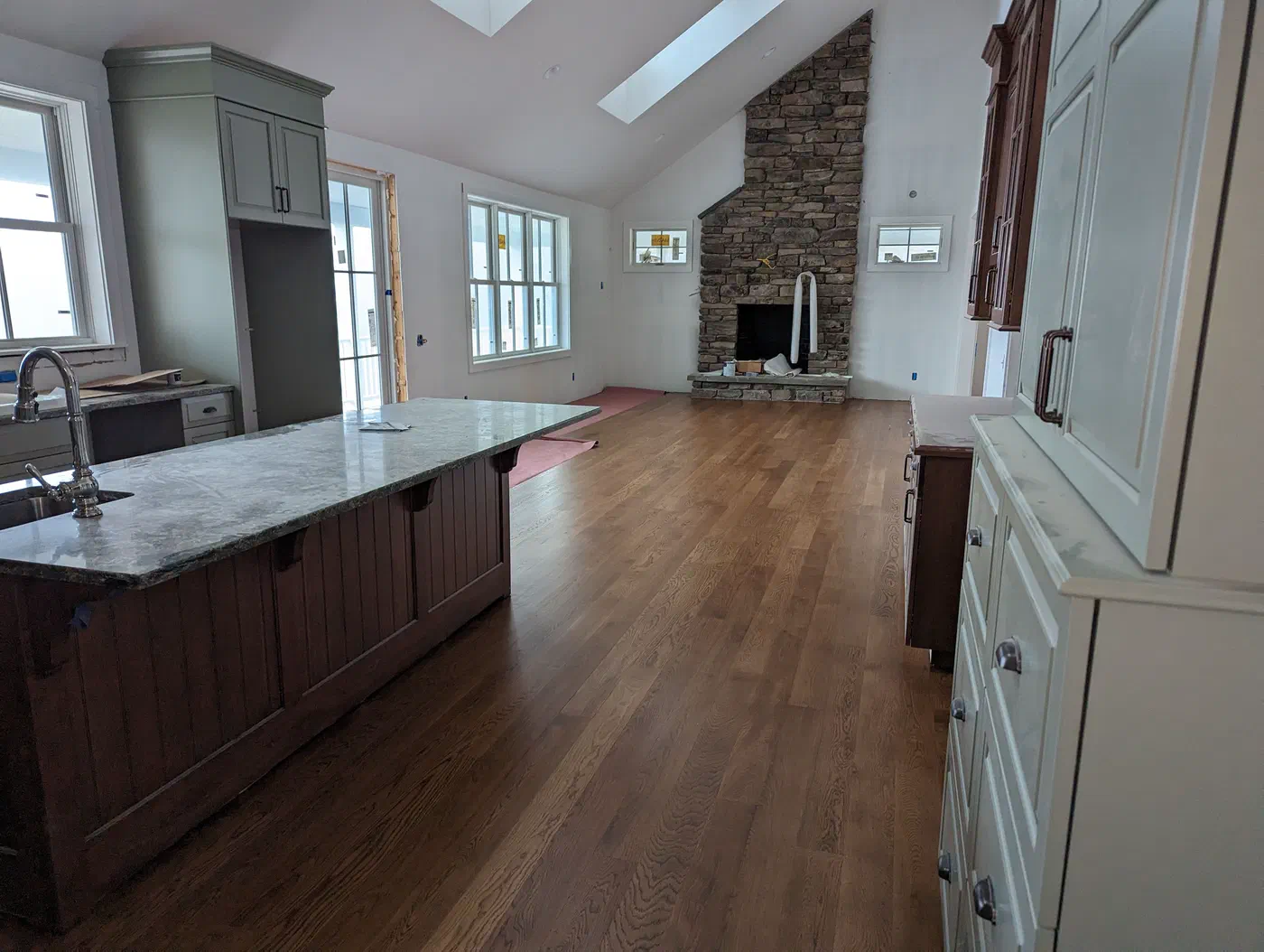 Open kitchen and living space with a stone fireplace