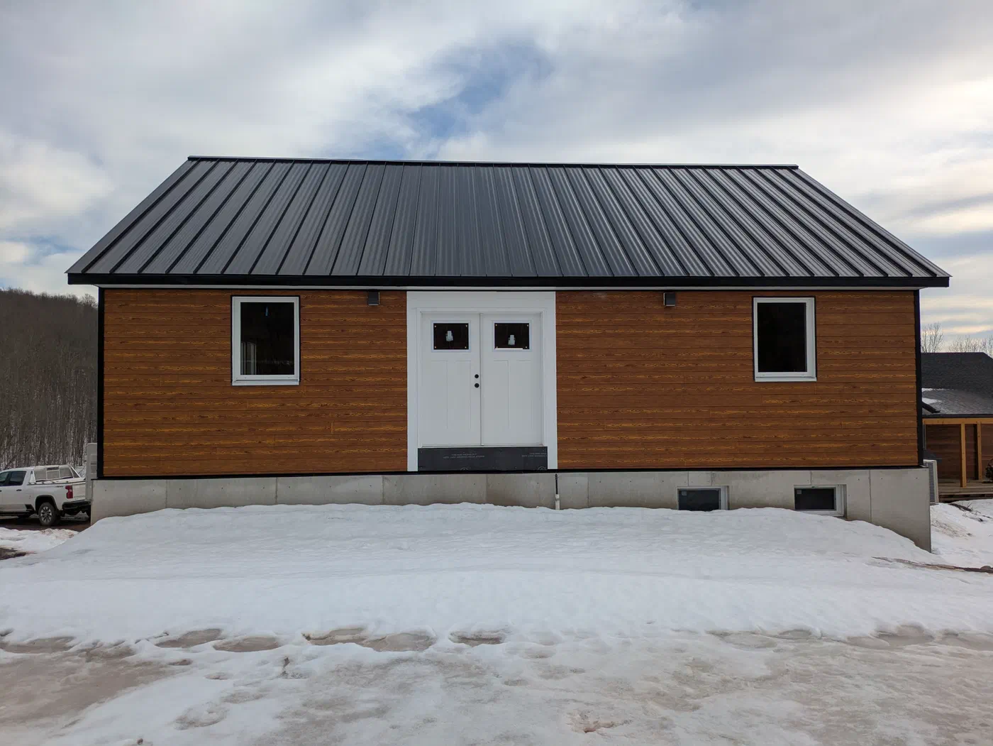 Lap siding, double doors and a black metal roof